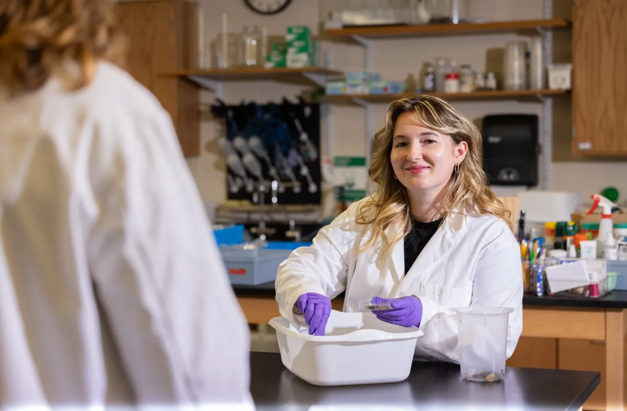 A student in a lab coat in Professor Marney Pratt's lab