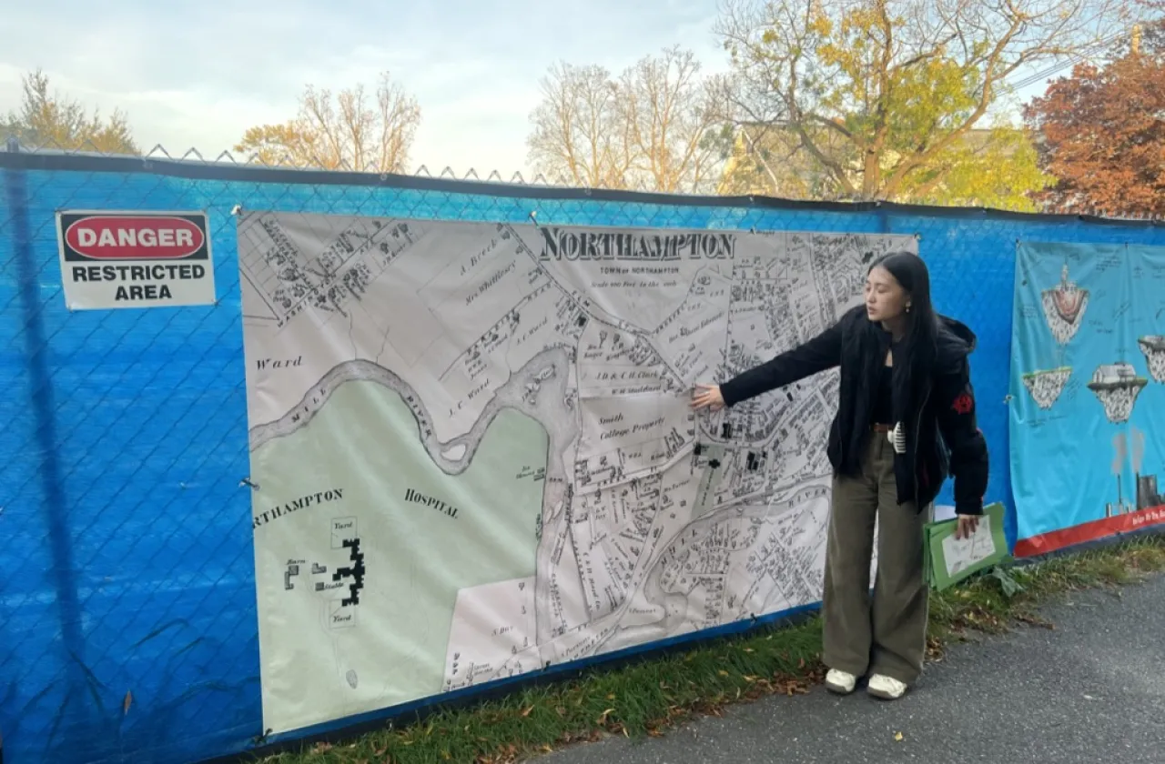 A student pointing at a geothermal banner on campus