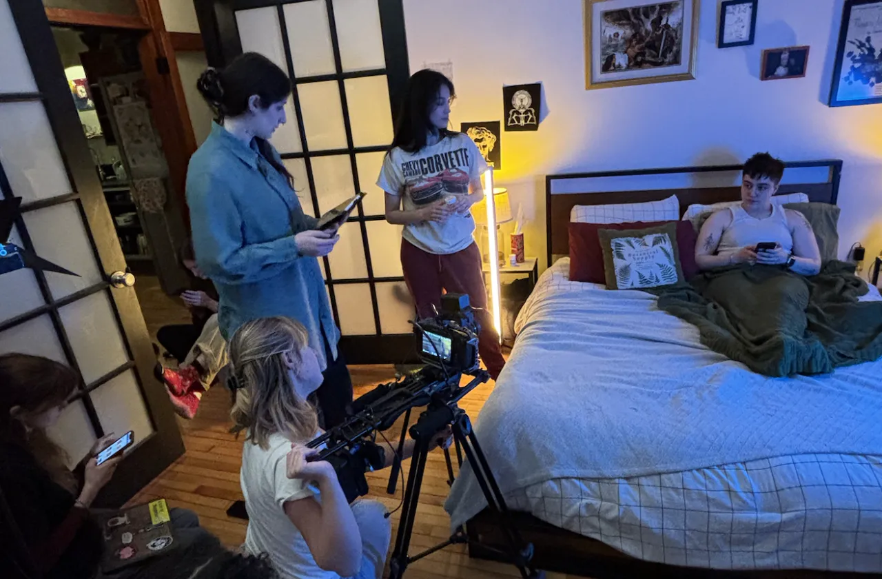 Students filming a movie in a dorm room.