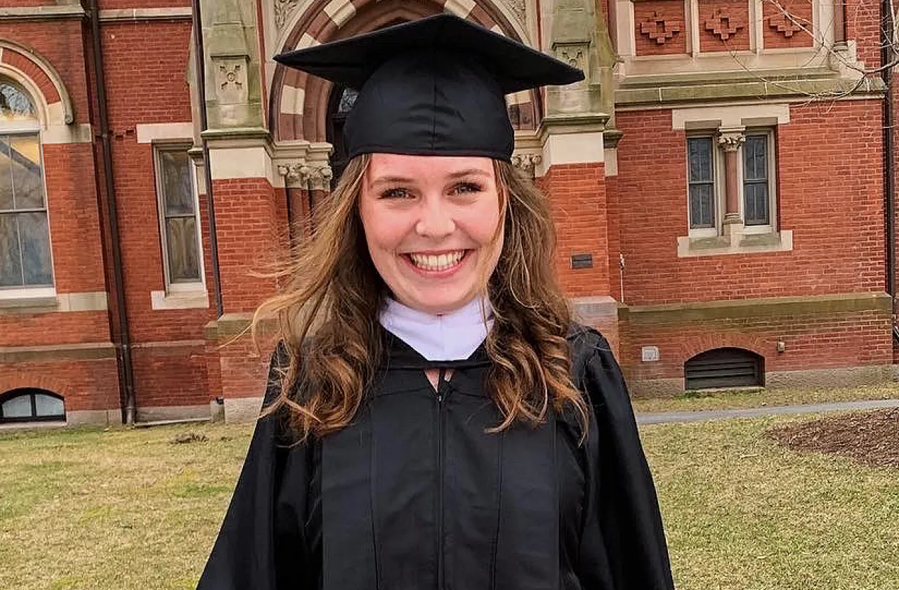 Emma Kemp in a graduation gown under the Grecourt Gate