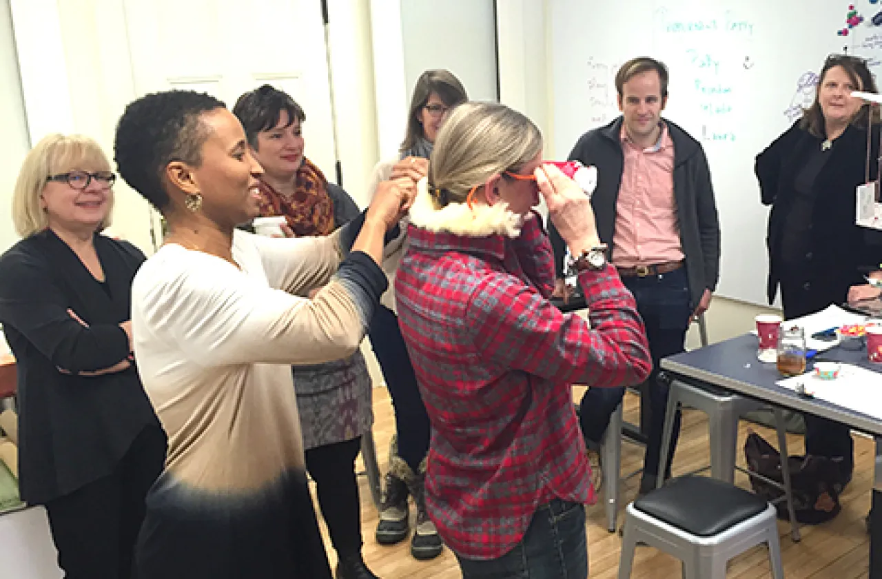 Digital scholarship librarian Miriam Neptune (front left) helps government professor Mlada Bukovansky put on goggles during a faculty workshop in the Design Thinking Initiative's new space in Capen Annex.
