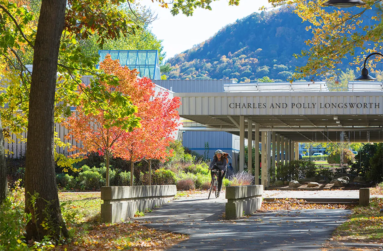 Student riding a bike on the Hampshire College campus
