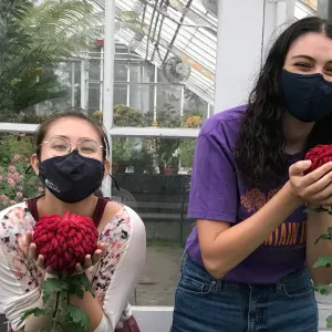 Mai Klooster and Sasha Zeidenberg holding large mum flowers