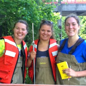 Smith juniors (from left) Emma Harnisch, Sally Cartarr and Lizzie Sturtevant measure water flow in Paradise Pond following a heavy rainfall.