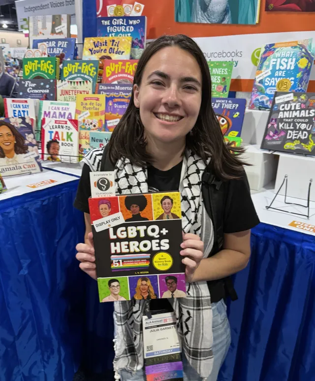 Julia Garnett '28 holds out a banned book at a library display.