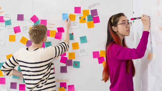Two students working on a whiteboard
