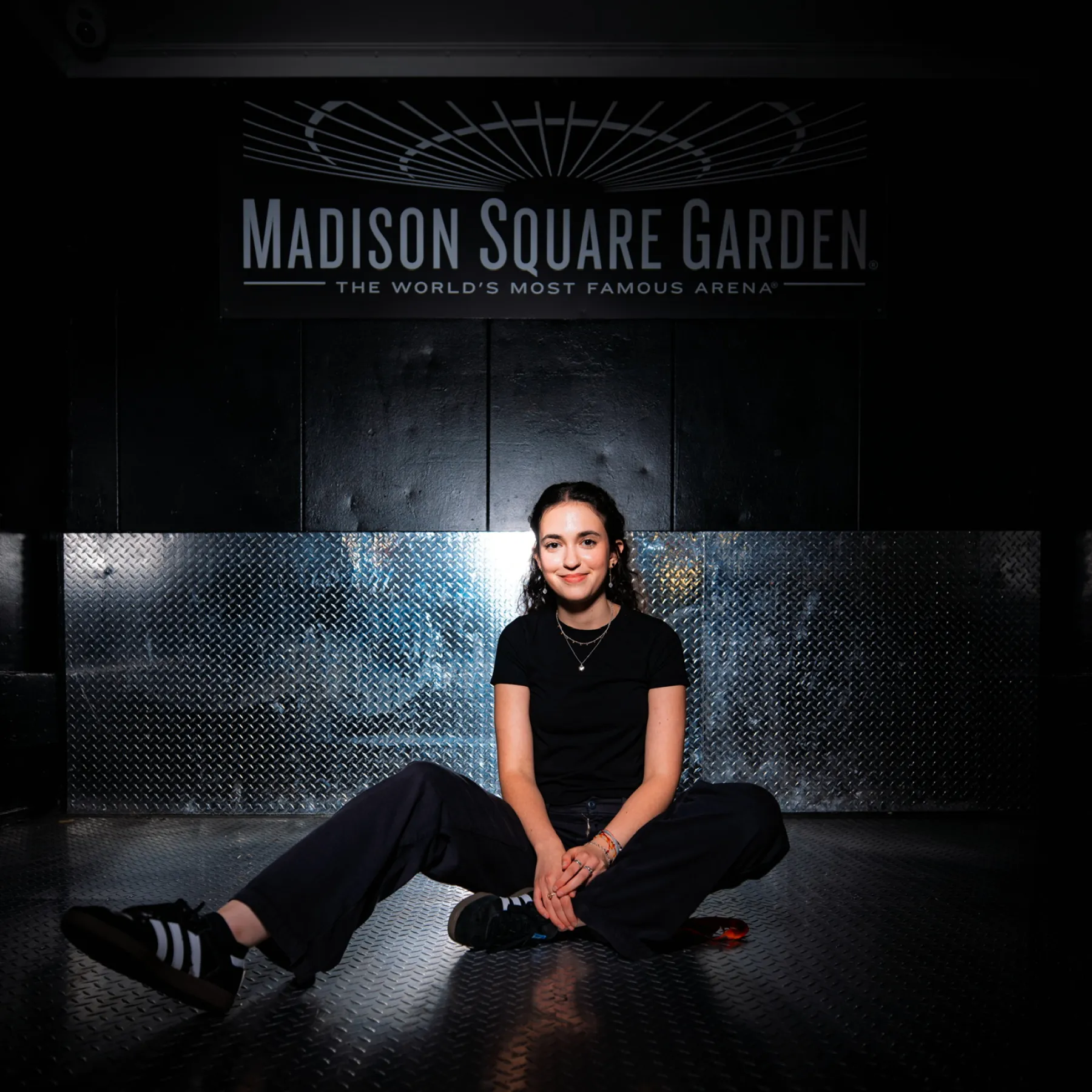 Elie Pichanick sits in front of a wall bearing the Madison Square Garden logo