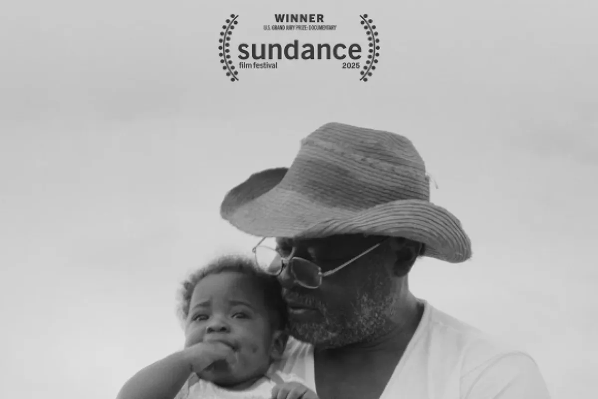 Black-and-white movie poster for the documentary "Seeds," showing a man wearing a sun hat and glasses holding a young baby outdoors. At the top, elegant cursive text reads "Seeds," above a Sundance Film Festival 2025 laureate laurel indicating "Winner: U.S. Grand Jury Prize: Documentary."