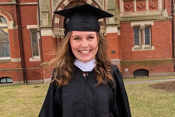 Emma Kemp in a graduation gown under the Grecourt Gate