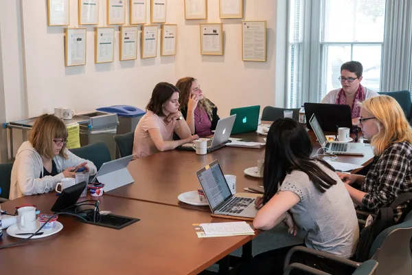 Students gathered around a table in the Kahn colloquium room