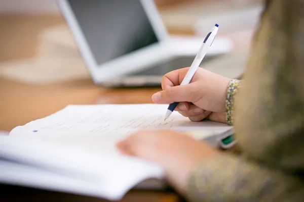 Closeup of a student writing in a notebook