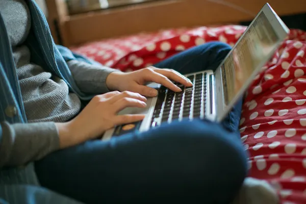 Closeup of a student typing on a laptop