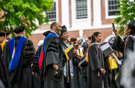A graduate and a professor take a photo together at Commencement