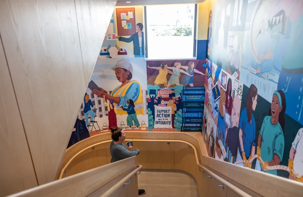 Someone stands and admires the new mural in Kathleen McCartney Hall.