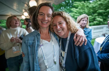 Two Smithies with their arms around each other's shoulders smile at the camera during Reunion