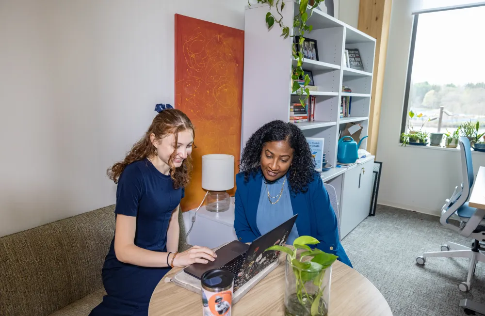 Two people sit and look at a laptop in Kathleen McCartney Hall
