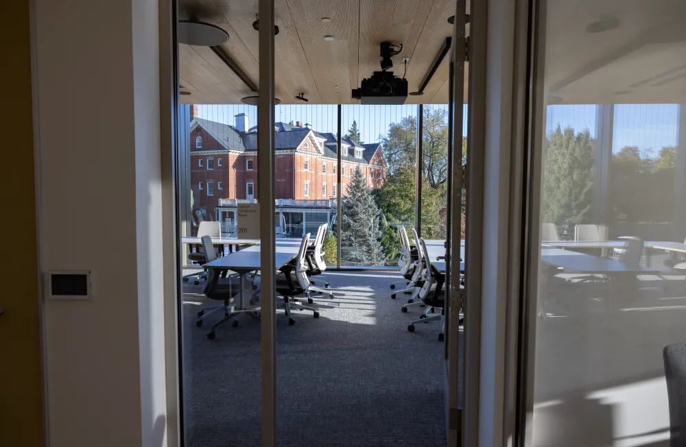 An empty conference room on the second floor of Kathleen McCartney Hall, with a view of Chapin House.
