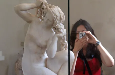 Student taking a photo of Greek statue