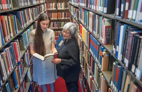Student and librarian in the stacks in Josten Library