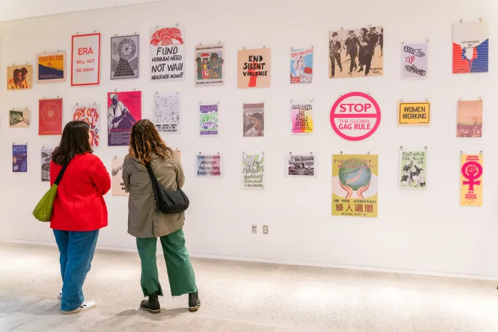 Two attendees look at a wall of art, during a special pop-up art installation. 