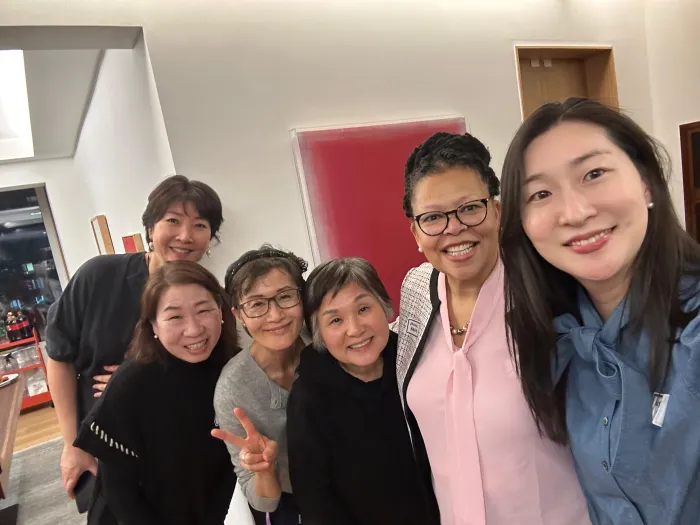 President Sarah Willie LeBreton poses with Diana Kang ‘78 and other alums in Diana's home.