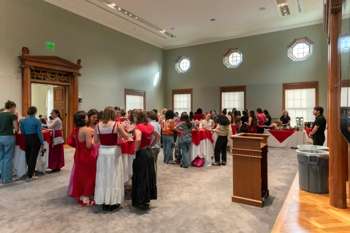 Students gathered in the Alumnae House, mingling and eating snacks
