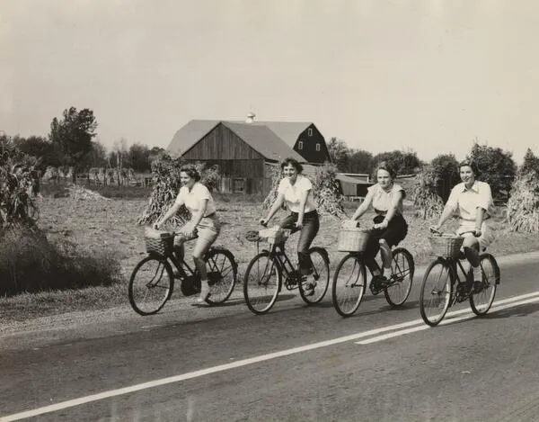 Smith students bicycle down the road on Mountain Day in 1950