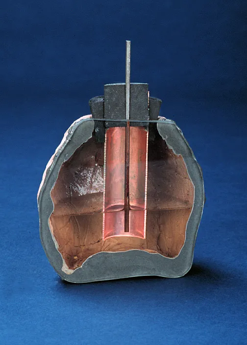 Cross-section of an ancient battery with visible inner components and a pink substance