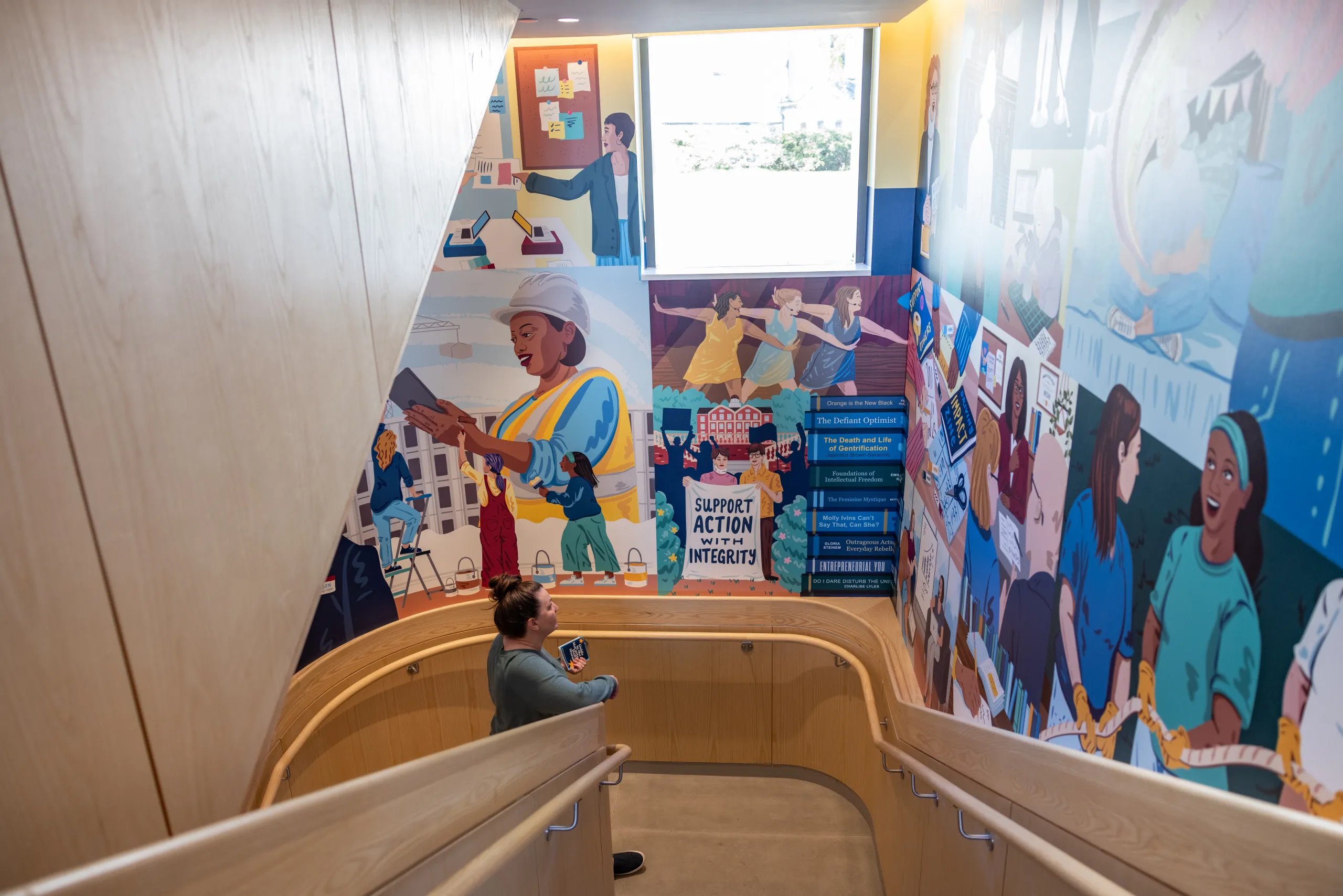 Someone stands and admires the new mural in Kathleen McCartney Hall.