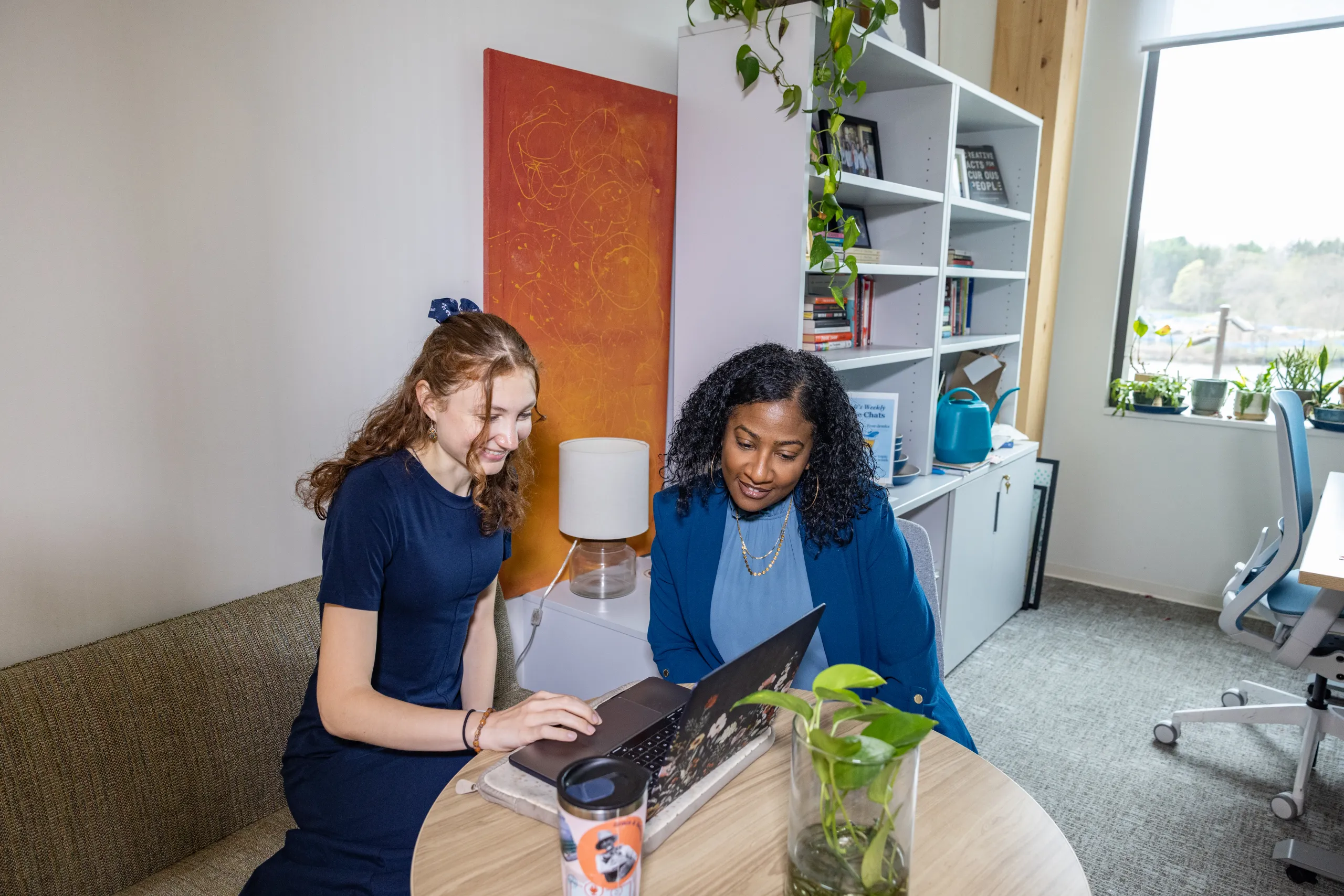 Two people sit and look at a laptop in Kathleen McCartney Hall