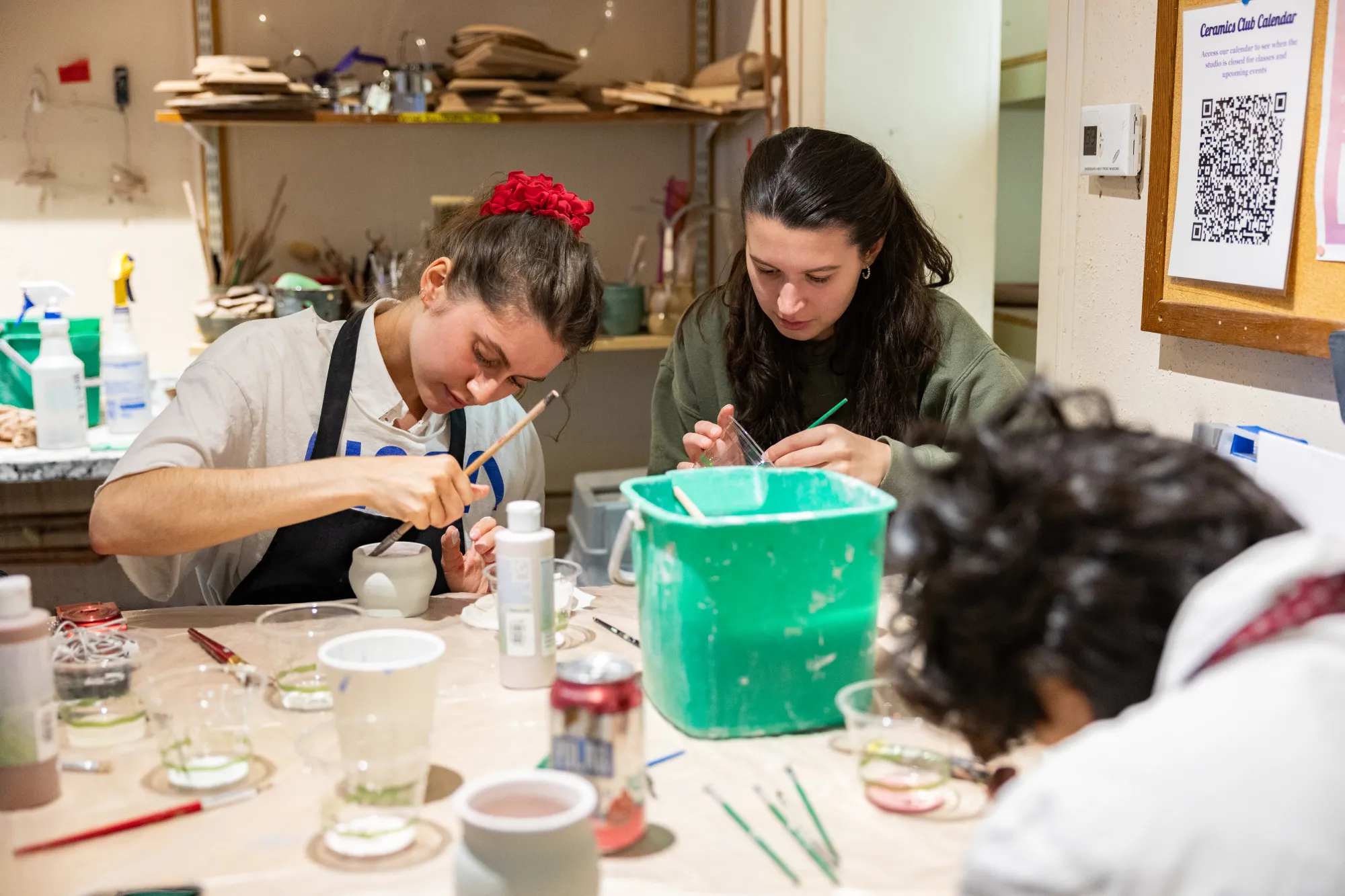 Members of the ceramics club painting some pieces.