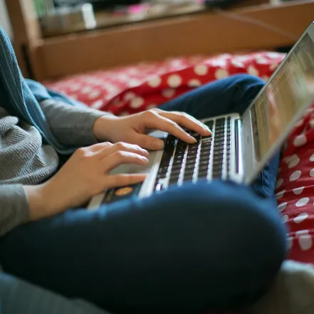 Closeup of a student typing on a laptop