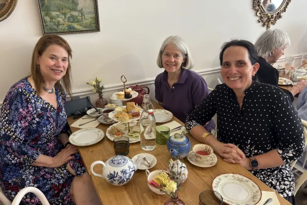 Three alums gather over tea.